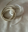 Coiled beige and white braided cordão fio de luz filamento 100% branco natural with brilho acetinado and seda técnica texture