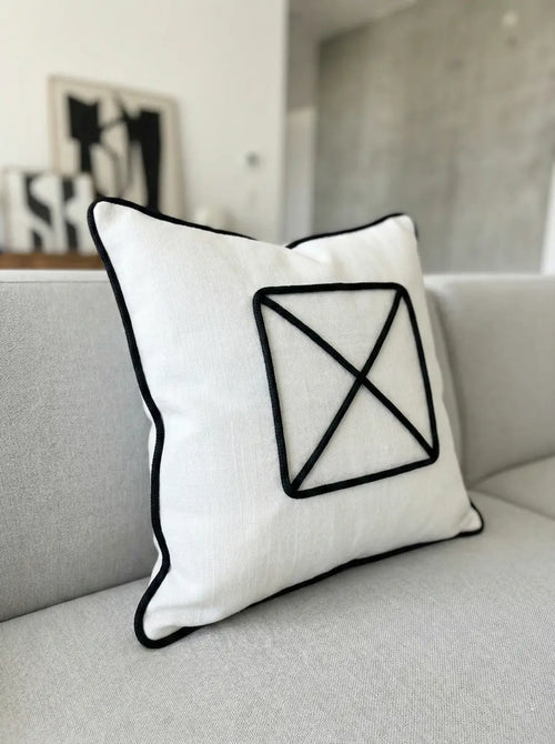 Almofada de linho branco com design geométrico bordado em preto e cordão grafite em contraste gráfico l&l