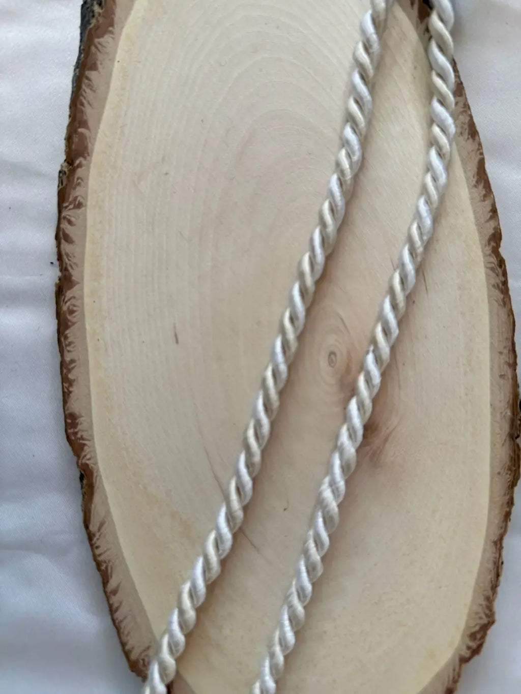 Cordão grand duke branco torcido em filamento 5mm 6mm sobre base de madeira clara