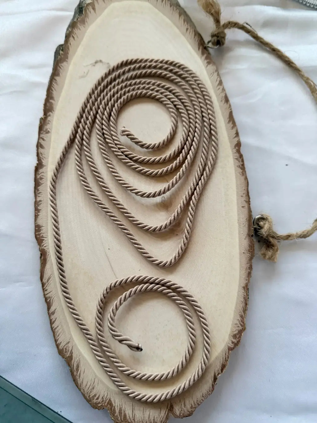 Cordão Riviera poliéster premium 3mm com padrão torcido em fibra natural sobre base de madeira rústica