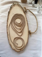 Beige twisted rope accessory coiled on rustic wood slice, luxury display product for storefront by L&L Concept Retail.