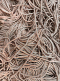 Uma massa emaranhada de cordão vivo multicolor em bege e cinzento com textura tricotada para projetos criativos