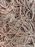 Uma massa emaranhada de cordão vivo multicolor em bege e cinzento com textura tricotada para projetos criativos