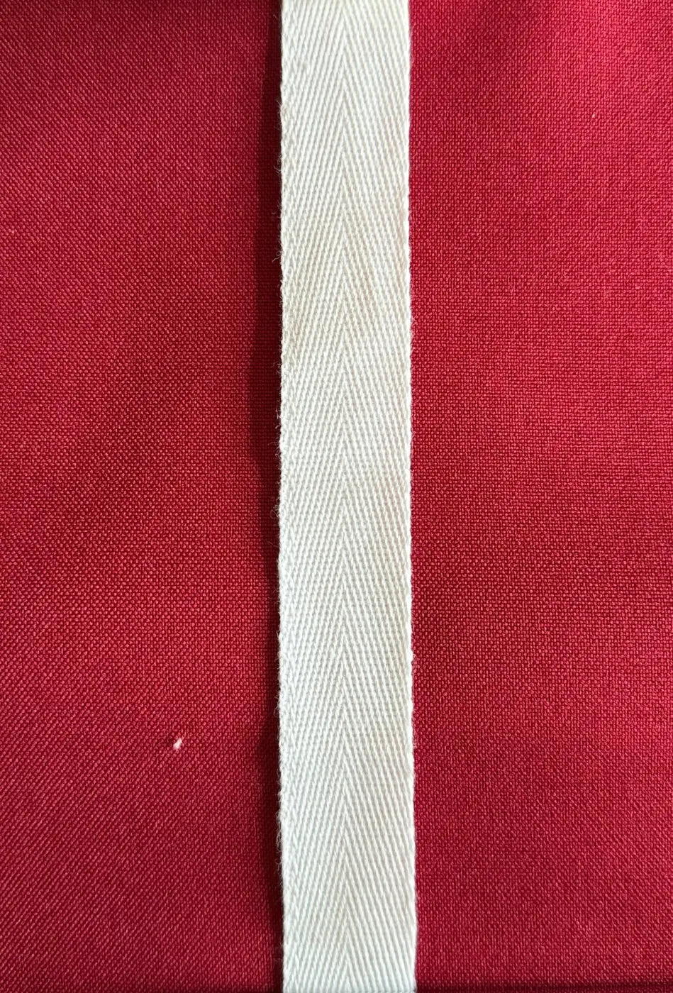 Fita sarja espinha 100% algodão natural branca com padrão herringbone sobre fundo vermelho para design orgânico e toque natural