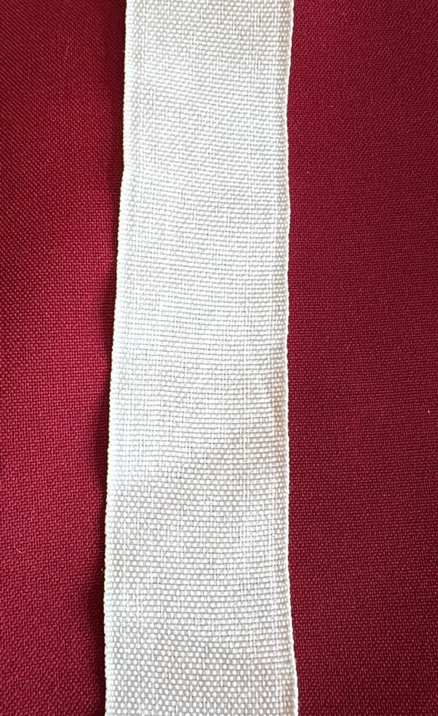 Fita tafetá estrutural poliéster 35mm cru em trama tafetá com largura standard sobre fundo vermelho