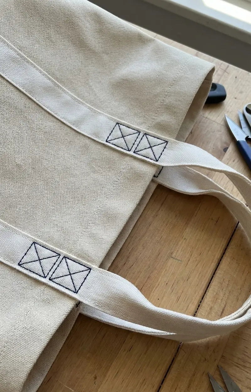 Beige bolsa de lona com padrão em quadrados pretos bordados nas pegas feita em fita tafetá de poliéster 35mm cru