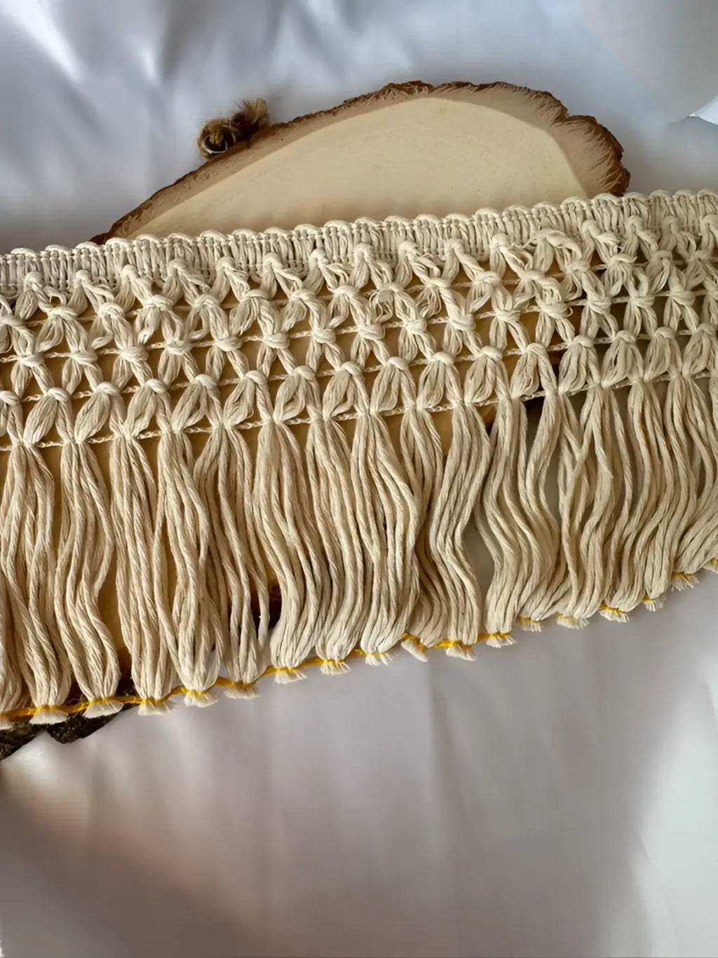 Franja alhambra algodão puro 130mm com franjas macramé creme e topo tecido exibido em fatia de madeira l&l