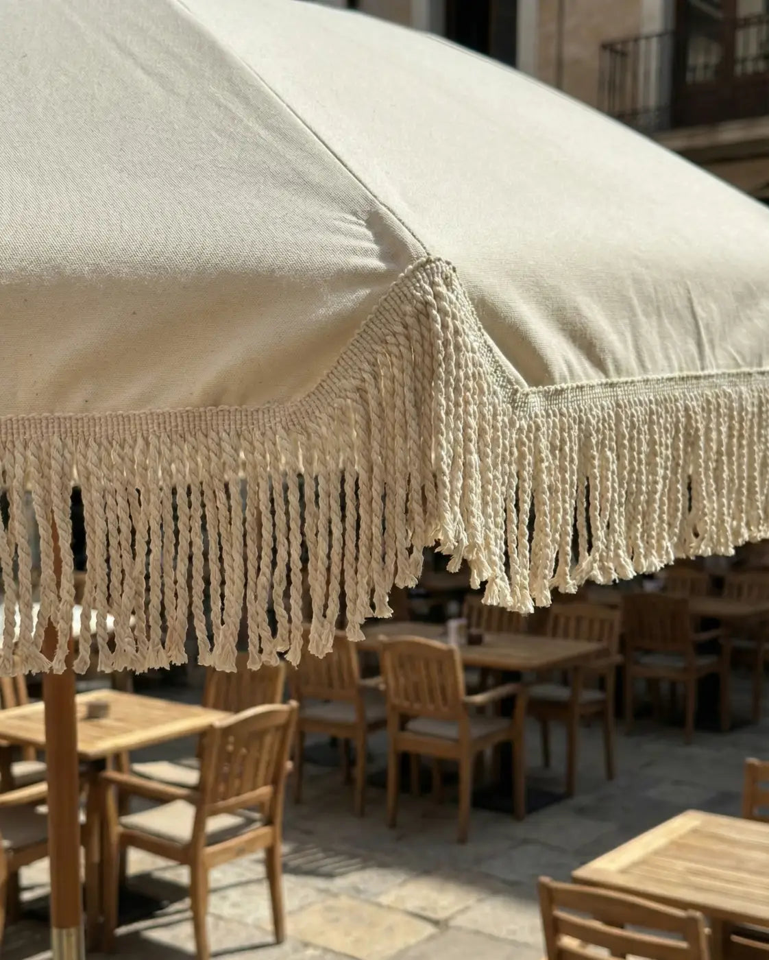 Cream-colored canvas patio umbrella with decorative macrame fringe franja manto alma estrutural l&l in algodão 80% natural