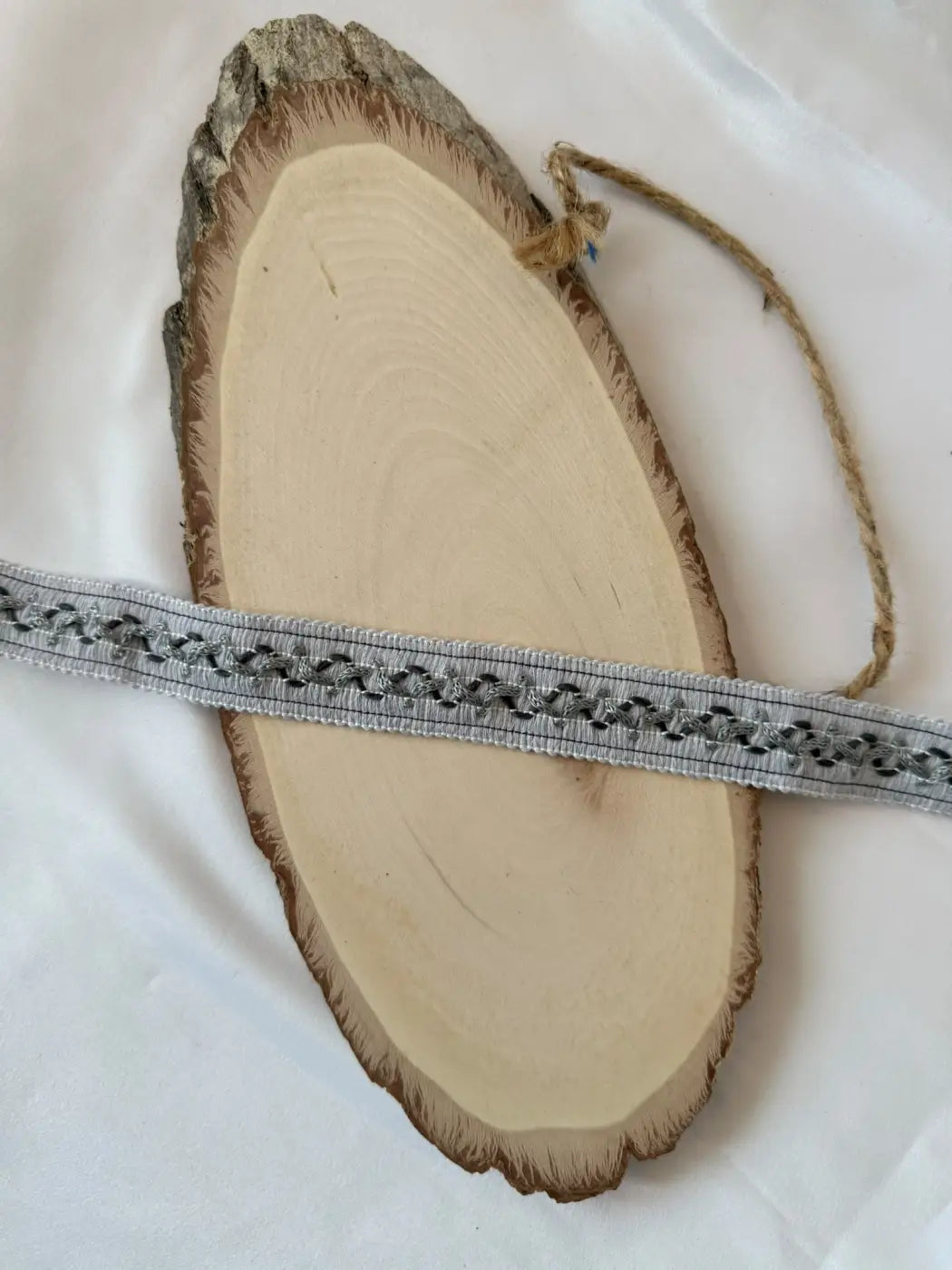 Galão fio de luz cinzento 80 algodão 2,5 cm com padrão preto subtil sobre fatia rústica de madeira l&l