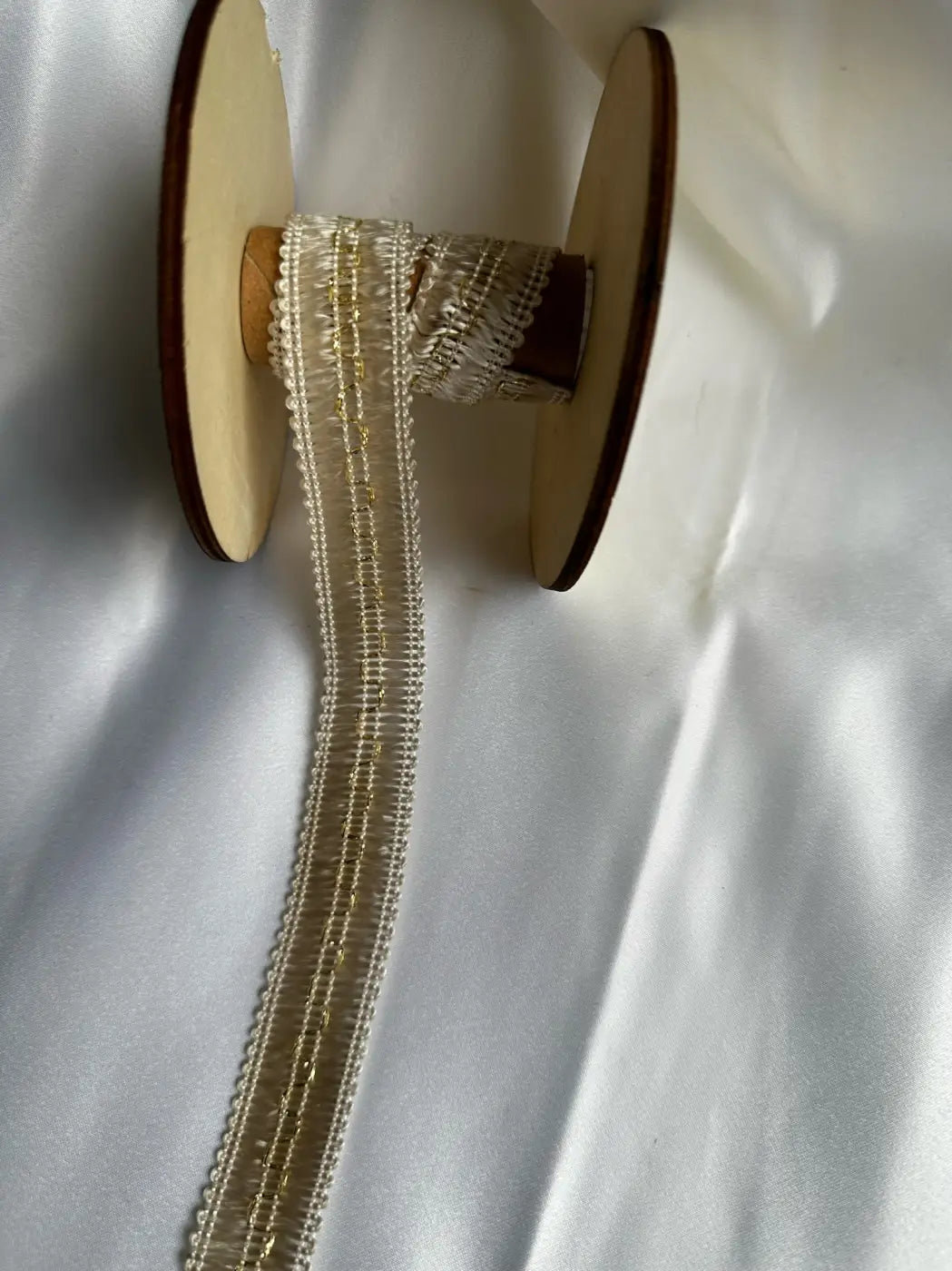 Galão ducale em filamento 80% 25mm com brilho metálico e alma estrutural em renda off-white com fio dourado