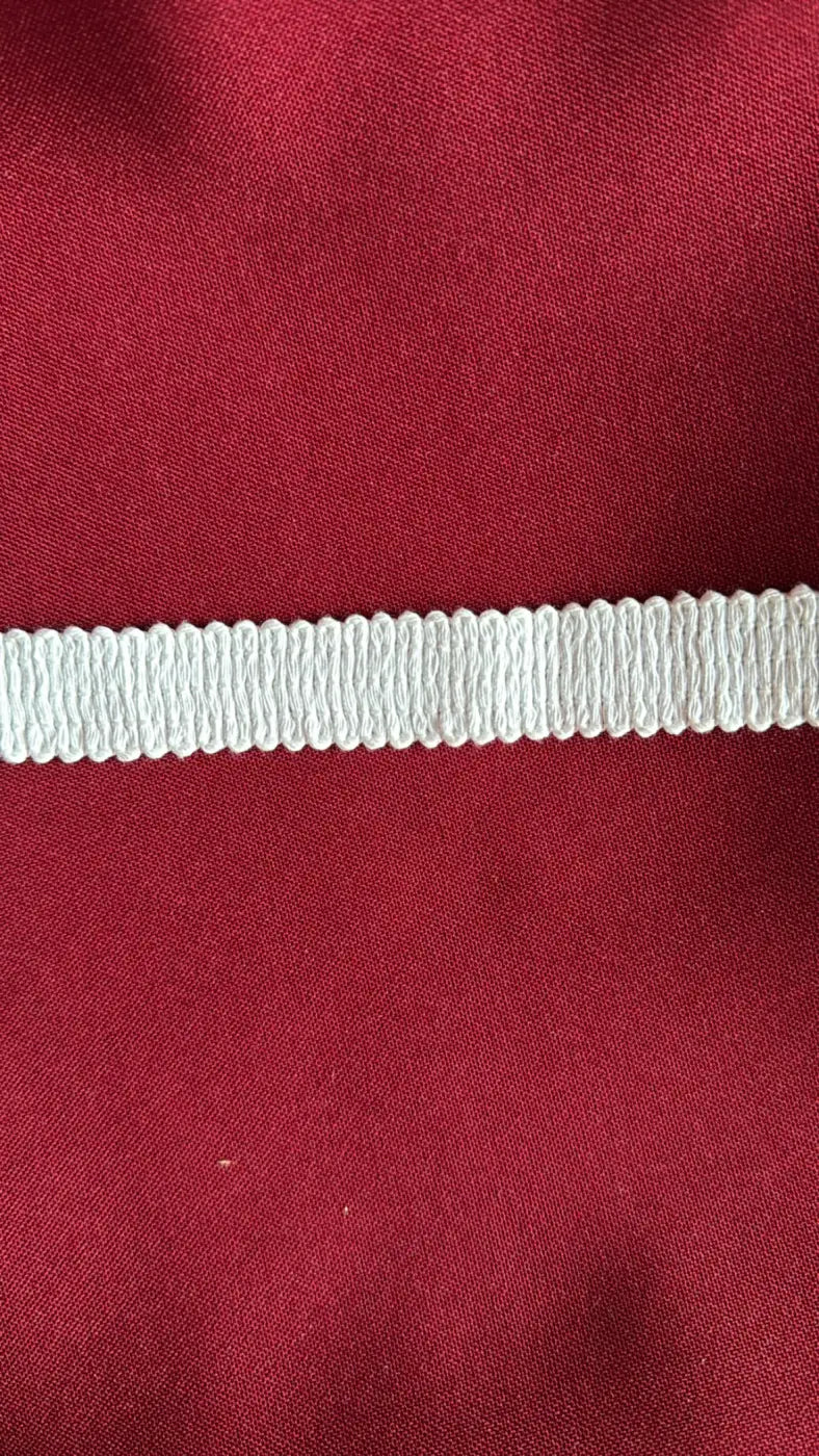 Galão savile de puro algodão nobre branco com costura canelada de 20 mm sobre fundo vermelho