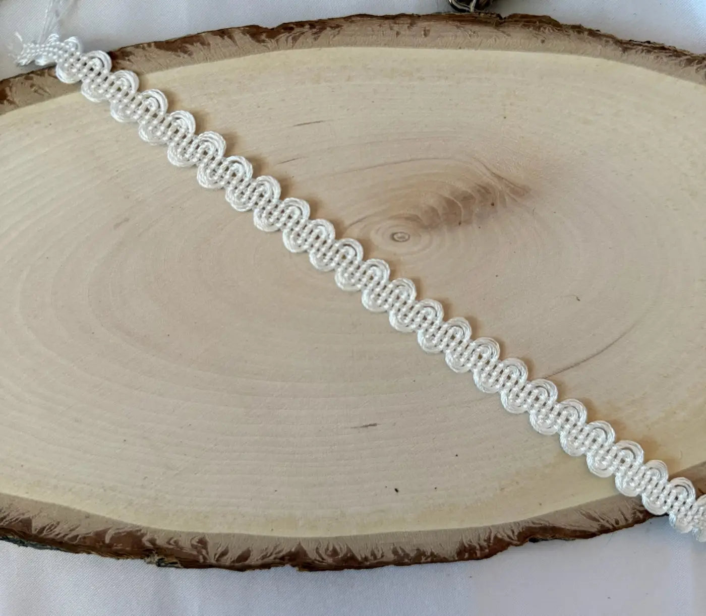 Galão trianon em renda branca com padrão delicado em scallop e acabamento discreto em rayon 10mm