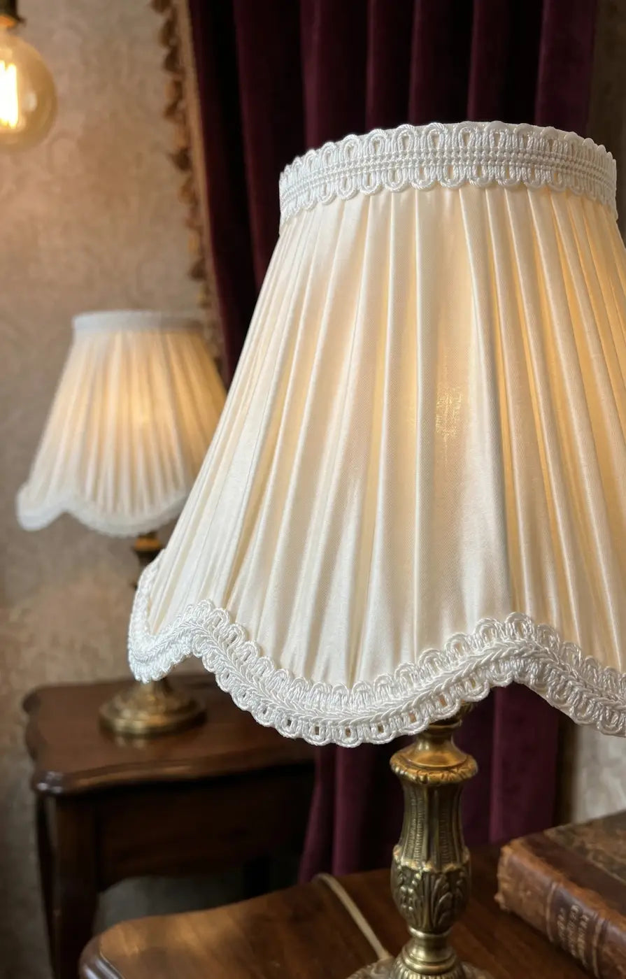 Cream-colored pleated lampshade with delicate white lace trim and subtle gold embroidery featuring galão vendôme rayon entrançado 25mm
