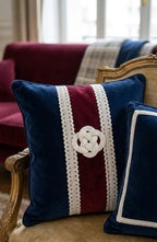 Navy blue velvet throw pillow with burgundy stripe, white lace trim, and embroidered celtic knot featuring galão vendôme